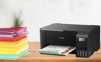 Impressora epson na mesa com varios papeis coloridos